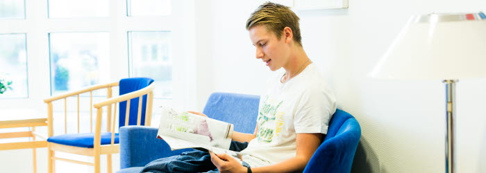 Ung man sitter och l&auml;ser